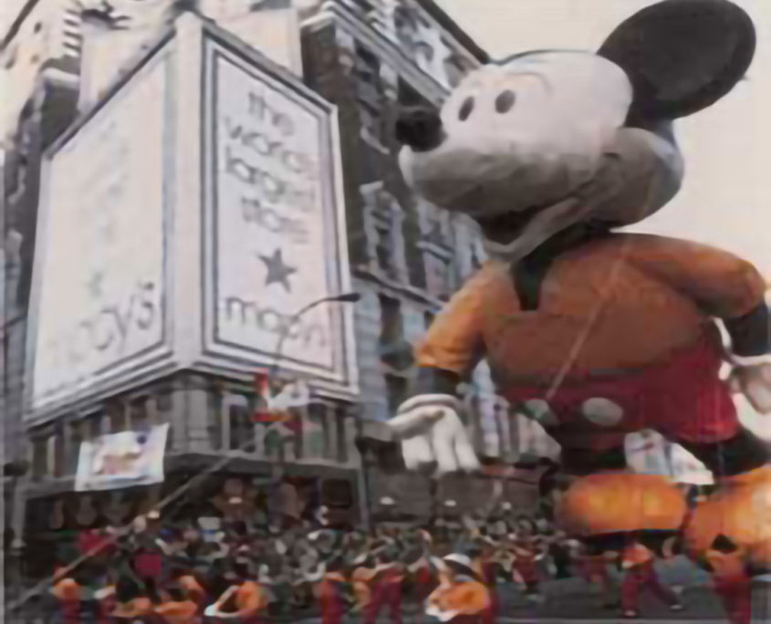 Mickey Mouse flying by the World's Largest Store. America's favorite mouse first flew in the Parade in the 1930's, a second version flew from 1968-82 and a new baloon led the Parade in 2000.